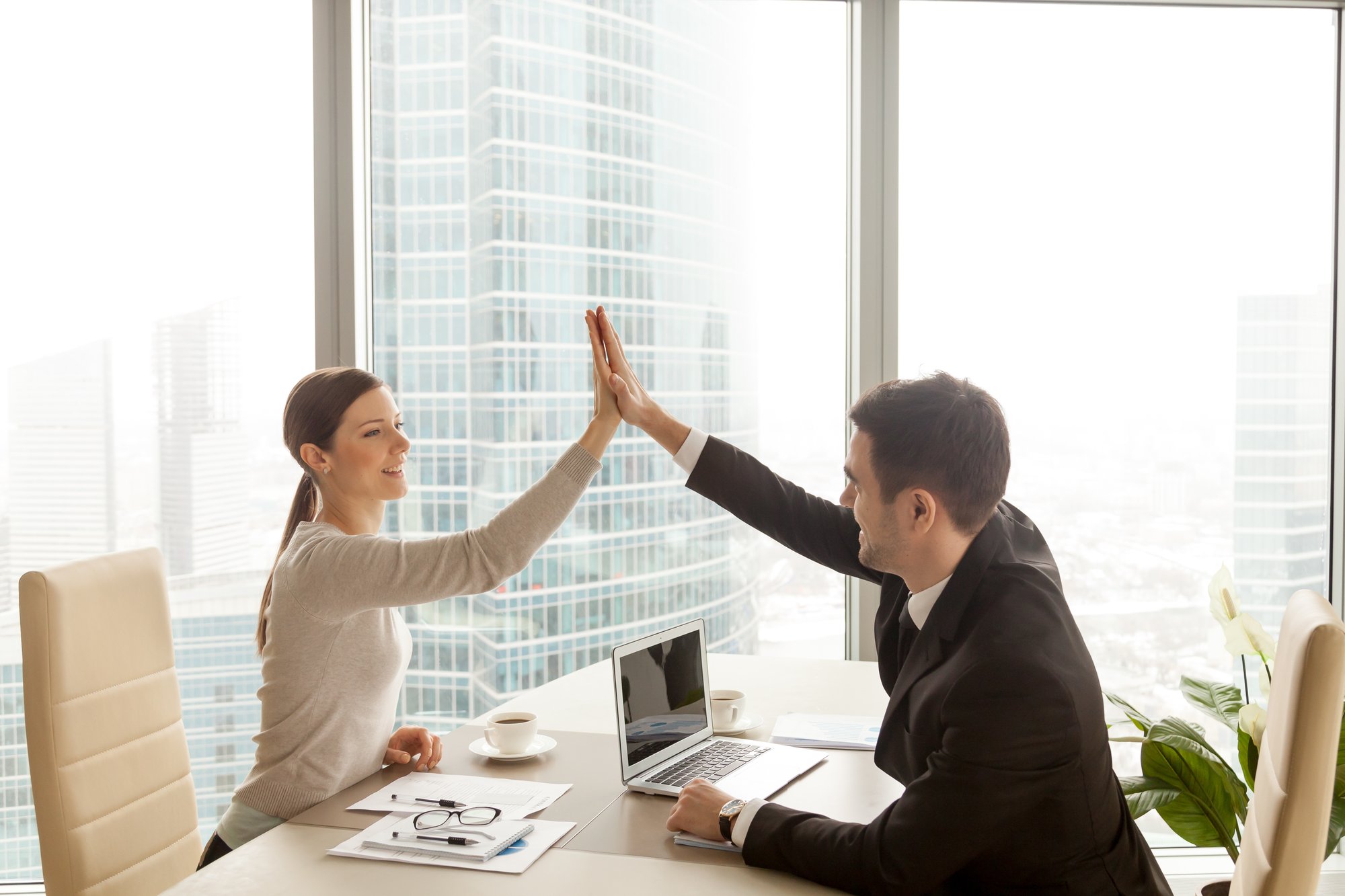 businessman-giving-businesswoman-high-five-office